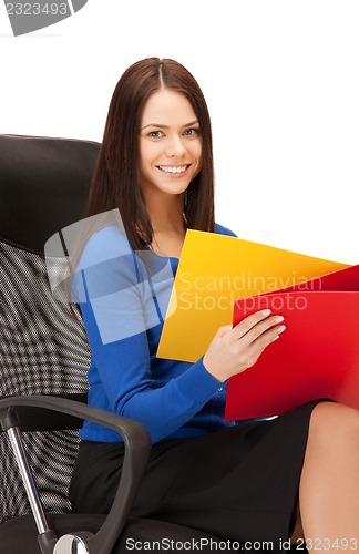 Image of young businesswoman with folders sitting in chair