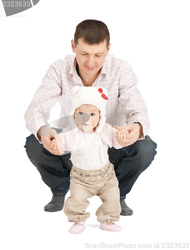 Image of baby making first steps with father help