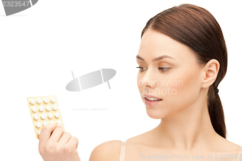 Image of young beautiful woman with pills