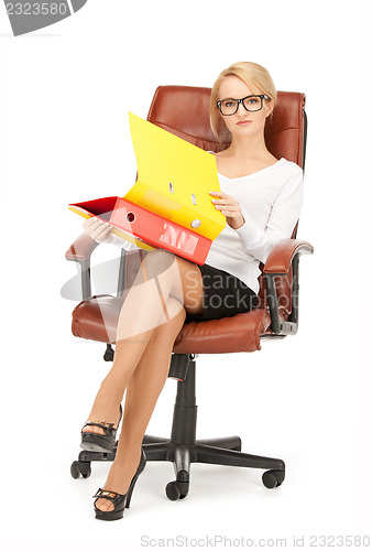 Image of young businesswoman with folders sitting in chair