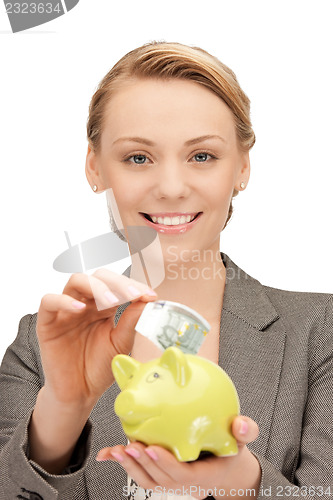 Image of lovely woman with piggy bank and money