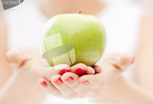Image of female hands with green apple