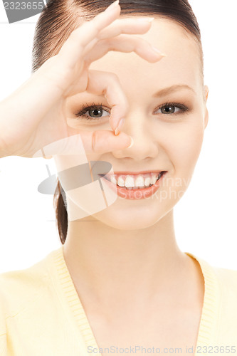 Image of lovely woman looking through hole from fingers