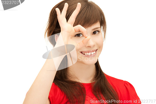 Image of teenage girl looking through hole from fingers