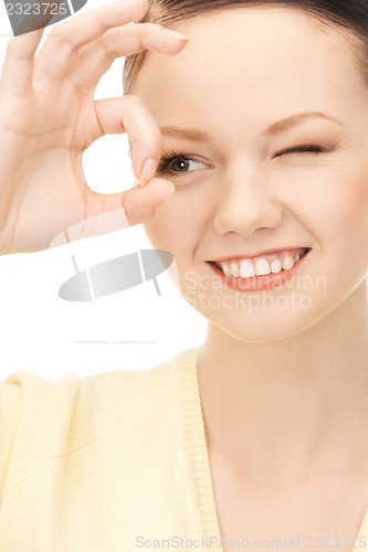 Image of lovely woman looking through hole from fingers