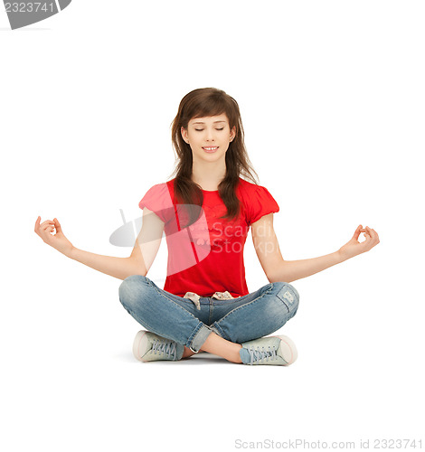Image of happy and carefree teenage girl in lotus pose