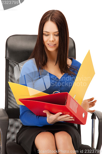 Image of young businesswoman with folders sitting in chair
