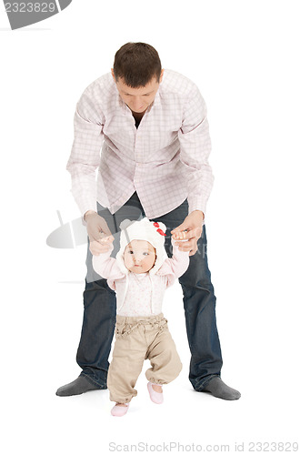 Image of baby making first steps with father help