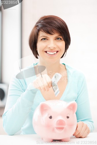 Image of lovely woman with piggy bank and money