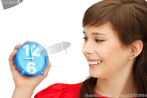Image of teenage girl holding alarm clock