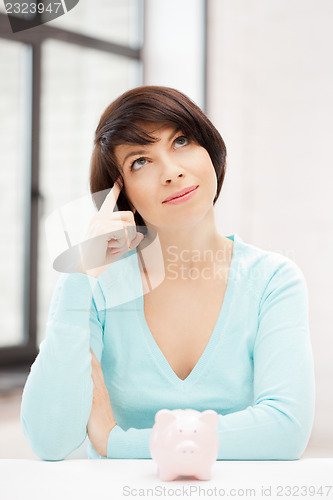 Image of lovely woman with piggy bank