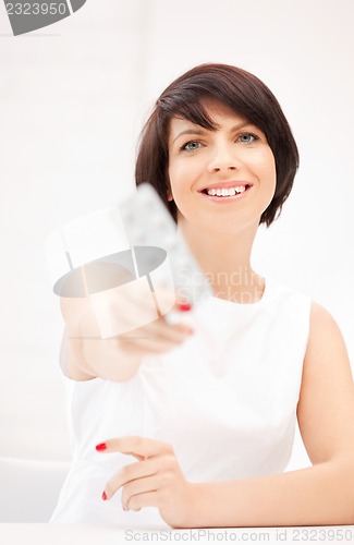 Image of young beautiful woman with pills