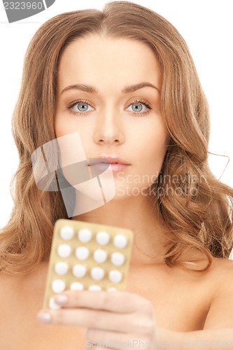 Image of young beautiful woman with pills