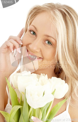 Image of cheerful blond with white tulips and phone