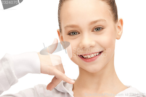Image of teenage girl making a call me gesture