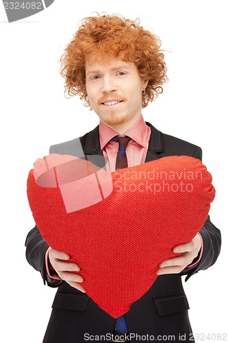 Image of handsome man with red heart-shaped pillow