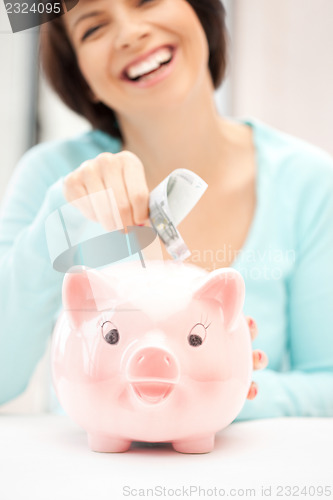 Image of lovely woman with piggy bank and money