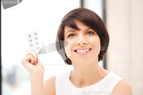 Image of young beautiful woman with pills