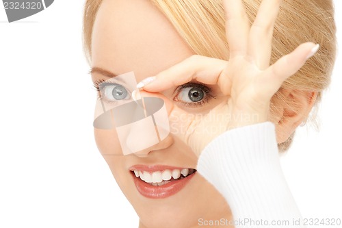 Image of lovely woman looking through hole from fingers