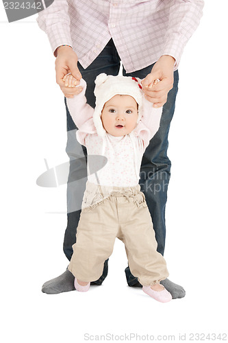 Image of baby making first steps with father help