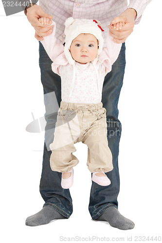 Image of baby hanging on fathers hands