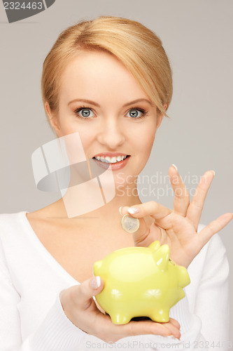 Image of lovely woman with piggy bank and money