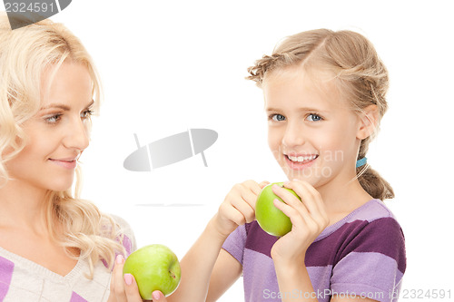 Image of mother and little girl with green apple