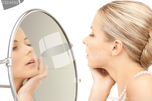 Image of beautiful woman with pearl beads and mirror