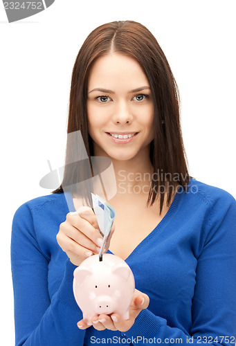 Image of lovely woman with piggy bank and money