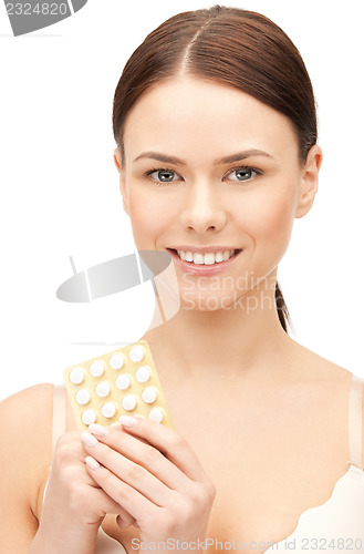 Image of young beautiful woman with pills