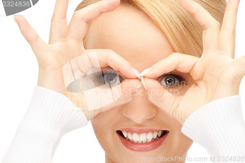 Image of lovely woman looking through hole from fingers