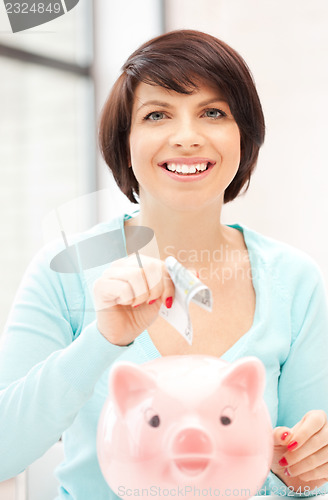 Image of lovely woman with piggy bank and money