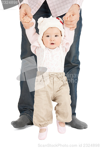 Image of baby making first steps with father help