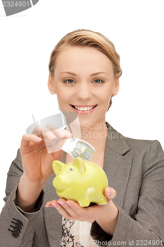 Image of lovely woman with piggy bank and money