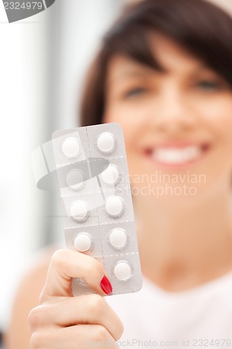 Image of young beautiful woman with pills