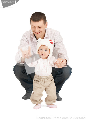 Image of baby making first steps with father help