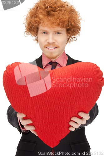 Image of handsome man with red heart-shaped pillow