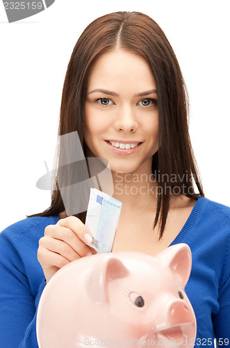 Image of lovely woman with piggy bank and money