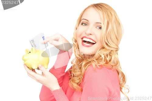 Image of lovely woman with piggy bank and money