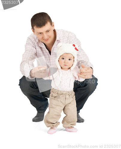 Image of baby making first steps with father help