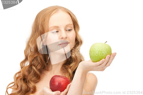 Image of young beautiful woman with green and red apples