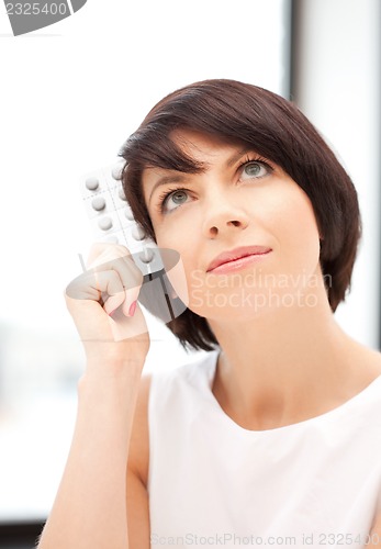 Image of young beautiful woman with pills