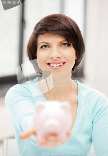 Image of lovely woman with piggy bank