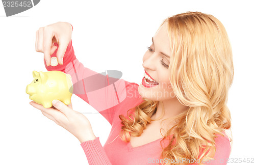 Image of lovely woman with piggy bank and money