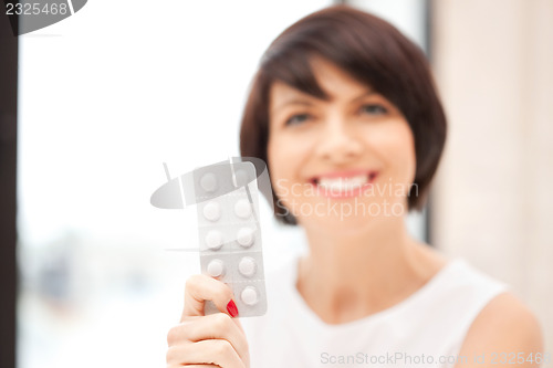 Image of young beautiful woman with pills