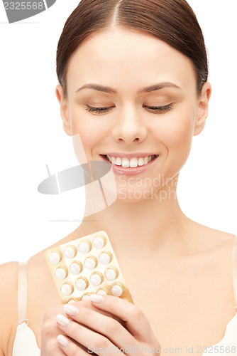 Image of young beautiful woman with pills