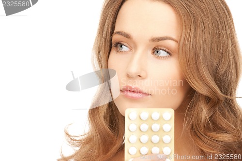 Image of young beautiful woman with pills