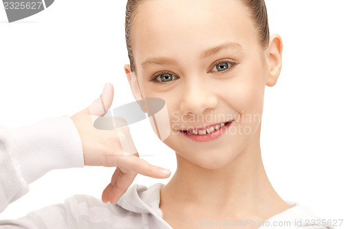 Image of teenage girl making a call me gesture