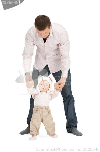 Image of baby making first steps with father help