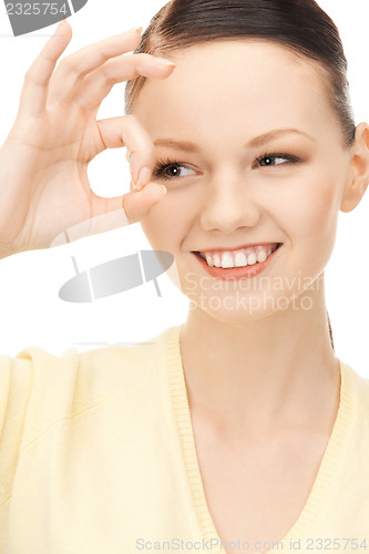 Image of lovely woman looking through hole from fingers